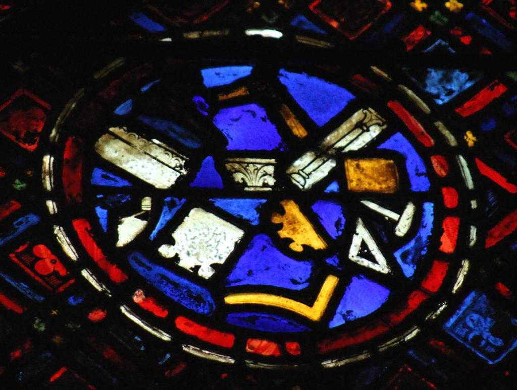 Image of glass panel depicting medieval masons' tools in the St Sylvester Window at Chartres Cathedral